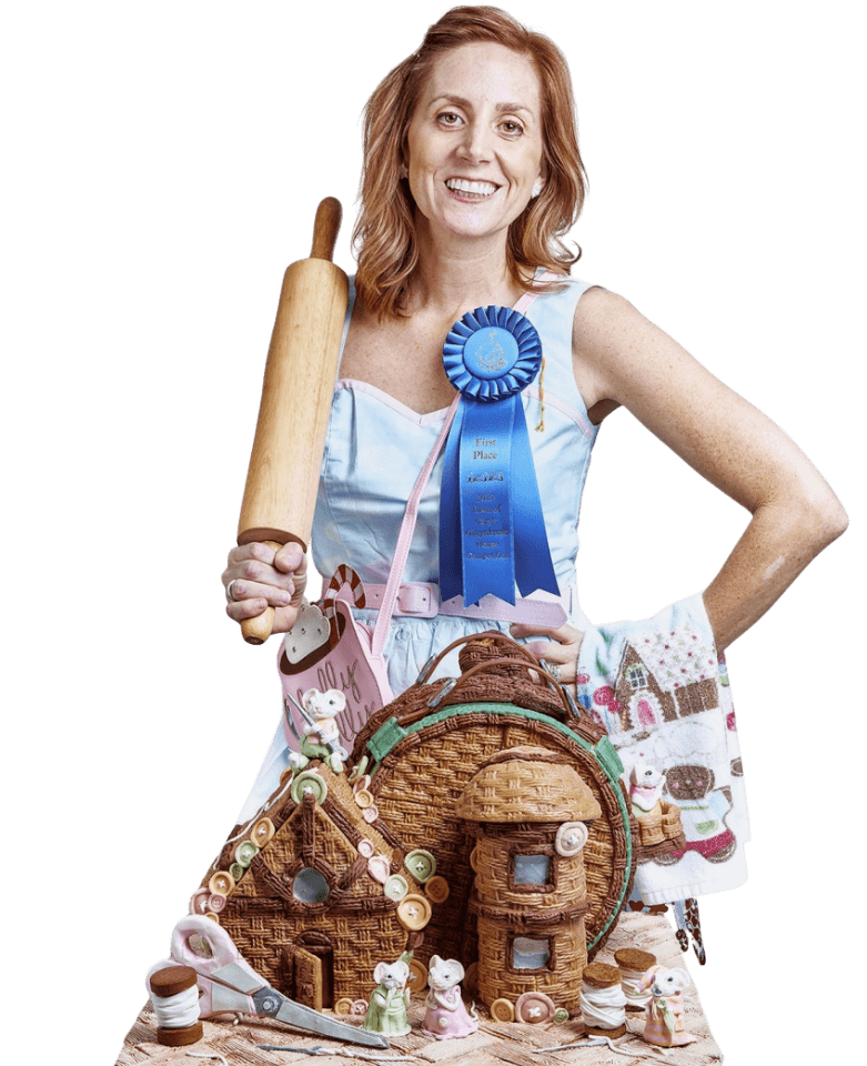 Woman with baking award and gingerbread house.